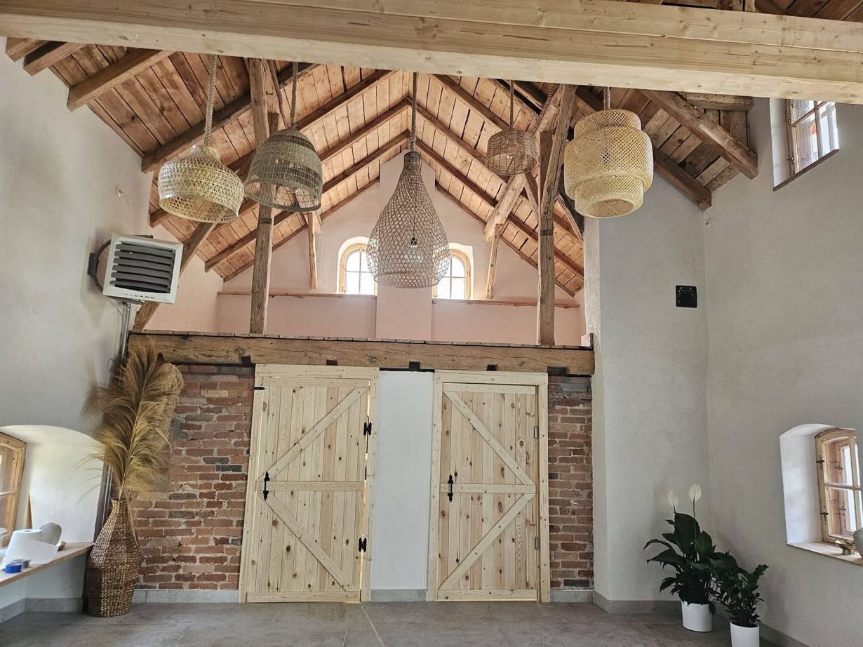 Gotowa sala z odsłoniętą więźbą i drewnianymi wrotami