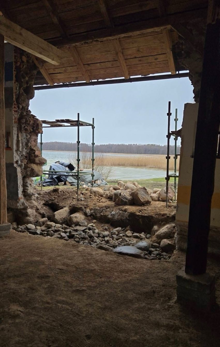 Wybity otwór w kamiennej ścianie z widokiem na jezioro